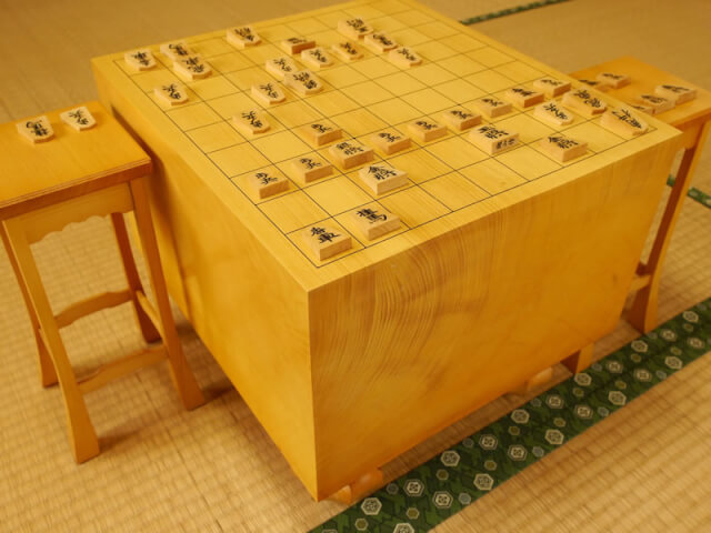 畳の上に置かれた対局途中の将棋盤と駒台